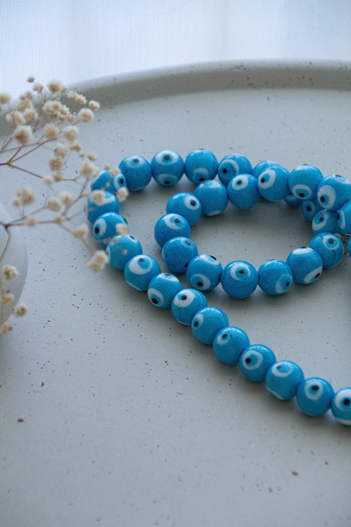 Evil eye bead strand • Turquoise evil eye • Glass bead evil eye • Handmade evil eye • Misbaha beads • Modern prayer beads • Table decor evil eye • Boho home decor • Evil eye protection • Middle Eastern home decor • Housewarming gift • Meaningful gift • Stylish Luck • Made in Israel
שרשרת עין הרע • חרוזי עין • קישוט שולחן • אובייקט עיצובי • חרוזי זכוכית בעבודת יד • מסבחה מודרנית • שמירה מעין הרע • עיצוב הבית • חפצי נוי • מתנה לחנוכת בית • מתנה משמעותית • סמלי מזל • Stylish Luck • מיוצר בישראל