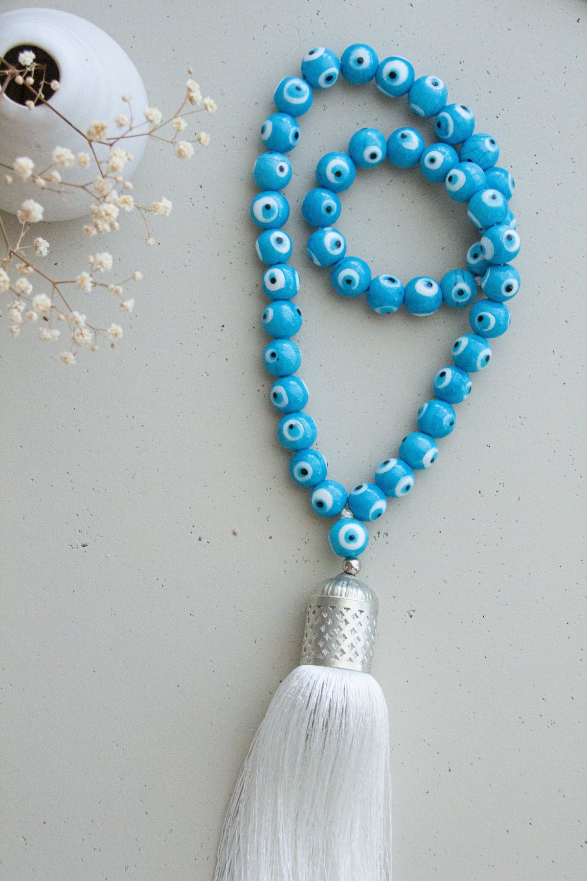 Evil eye bead strand • Turquoise evil eye • Glass bead evil eye • Handmade evil eye • Misbaha beads • Modern prayer beads • Table decor evil eye • Boho home decor • Evil eye protection • Middle Eastern home decor • Housewarming gift • Meaningful gift • Stylish Luck • Made in Israel 
שרשרת עין הרע • חרוזי עין • קישוט שולחן • אובייקט עיצובי • חרוזי זכוכית בעבודת יד • מסבחה מודרנית • שמירה מעין הרע • עיצוב הבית • חפצי נוי • מתנה לחנוכת בית • מתנה משמעותית • סמלי מזל • Stylish Luck • מיוצר בישראל
