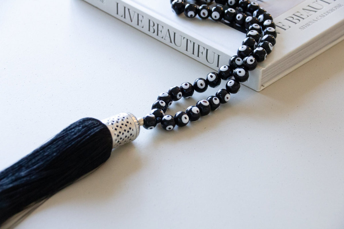 Evil eye bead strand • Black evil eye • Glass bead evil eye • Handmade evil eye • Misbaha beads • Modern prayer beads • Table decor evil eye • Boho home decor • Evil eye protection • Middle Eastern home decor • Housewarming gift • Meaningful gift • Stylish Luck • Made in Israel

שרשרת עין הרע • חרוזי עין • קישוט שולחן • אובייקט עיצובי • חרוזי זכוכית בעבודת יד • מסבחה מודרנית • שמירה מעין הרע • עיצוב הבית • חפצי נוי • מתנה לחנוכת בית • מתנה משמעותית • סמלי מזל • Stylish Luck • מיוצר בישראל