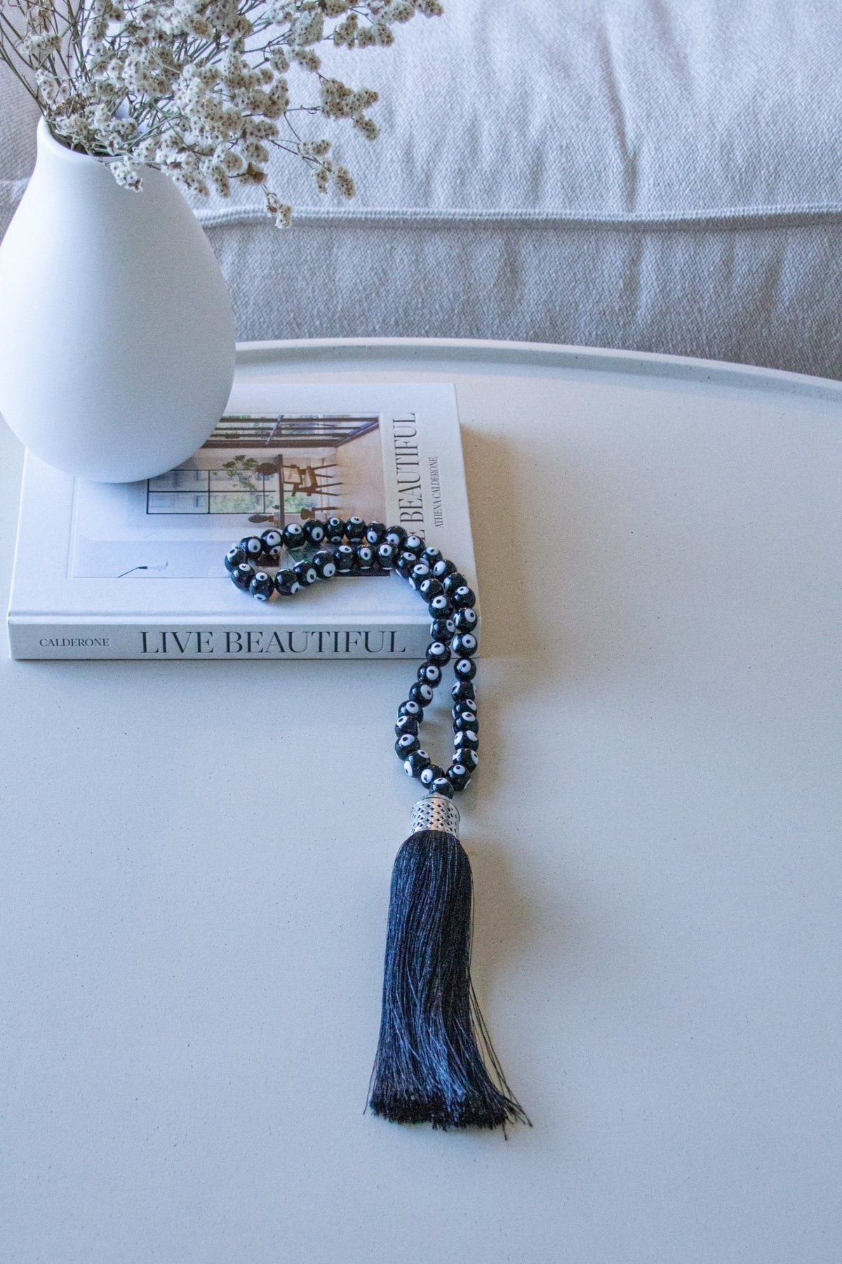 Evil eye bead strand • Black evil eye • Glass bead evil eye • Handmade evil eye • Misbaha beads • Modern prayer beads • Table decor evil eye • Boho home decor • Evil eye protection • Middle Eastern home decor • Housewarming gift • Meaningful gift • Stylish Luck • Made in Israel

שרשרת עין הרע • חרוזי עין • קישוט שולחן • אובייקט עיצובי • חרוזי זכוכית בעבודת יד • מסבחה מודרנית • שמירה מעין הרע • עיצוב הבית • חפצי נוי • מתנה לחנוכת בית • מתנה משמעותית • סמלי מזל • Stylish Luck • מיוצר בישראל