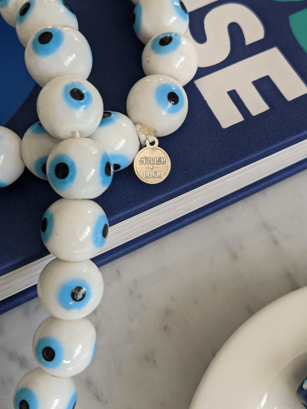 
Evil eye bead strand • Blue evil eye • Glass bead evil eye • Handmade evil eye • Misbaha beads • Modern prayer beads • Table decor evil eye • Boho home decor • Evil eye protection • Middle Eastern home decor • Housewarming gift • Meaningful gift • Stylish Luck • Made in Israel

שרשרת עין הרע • חרוזי עין • קישוט שולחן • אובייקט עיצובי • חרוזי זכוכית בעבודת יד • מסבחה מודרנית • שמירה מעין הרע • עיצוב הבית • חפצי נוי • מתנה לחנוכת בית • מתנה משמעותית • סמלי מזל • Stylish Luck • מיוצר בישראל