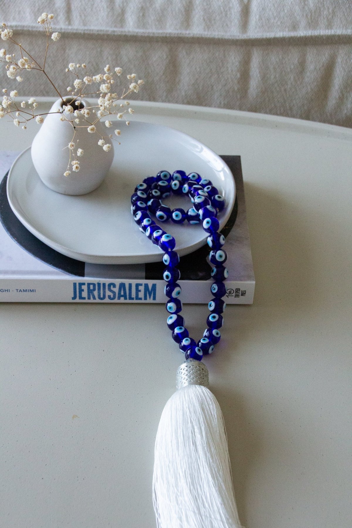 
Evil eye bead strand • Blue evil eye • Glass bead evil eye • Handmade evil eye • Misbaha beads • Modern prayer beads • Table decor evil eye • Boho home decor • Evil eye protection • Mediterranean home decor • Housewarming gift • Meaningful gift • Stylish Luck • Made in Israel
שרשרת עין הרע • חרוזי עין • שרשרת חרוזי זכוכית • עין הרע לבית • קישוט שולחן • אובייקט עיצובי
